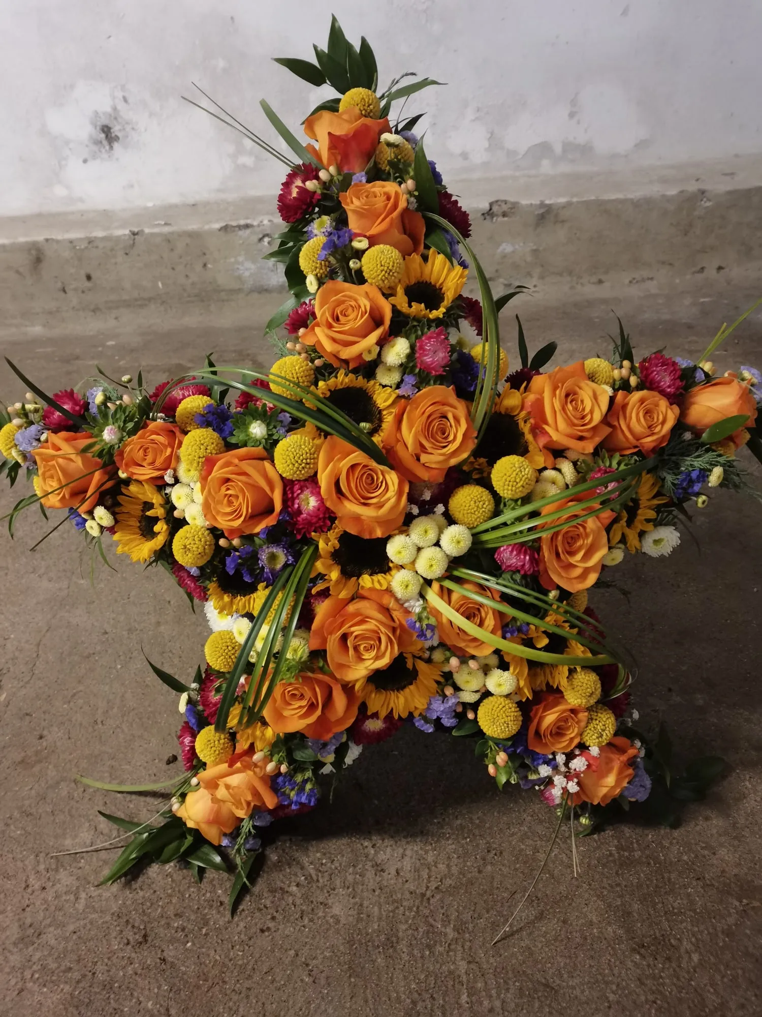 Stern aus orangefarbenen Rosen und Sonnenblumen