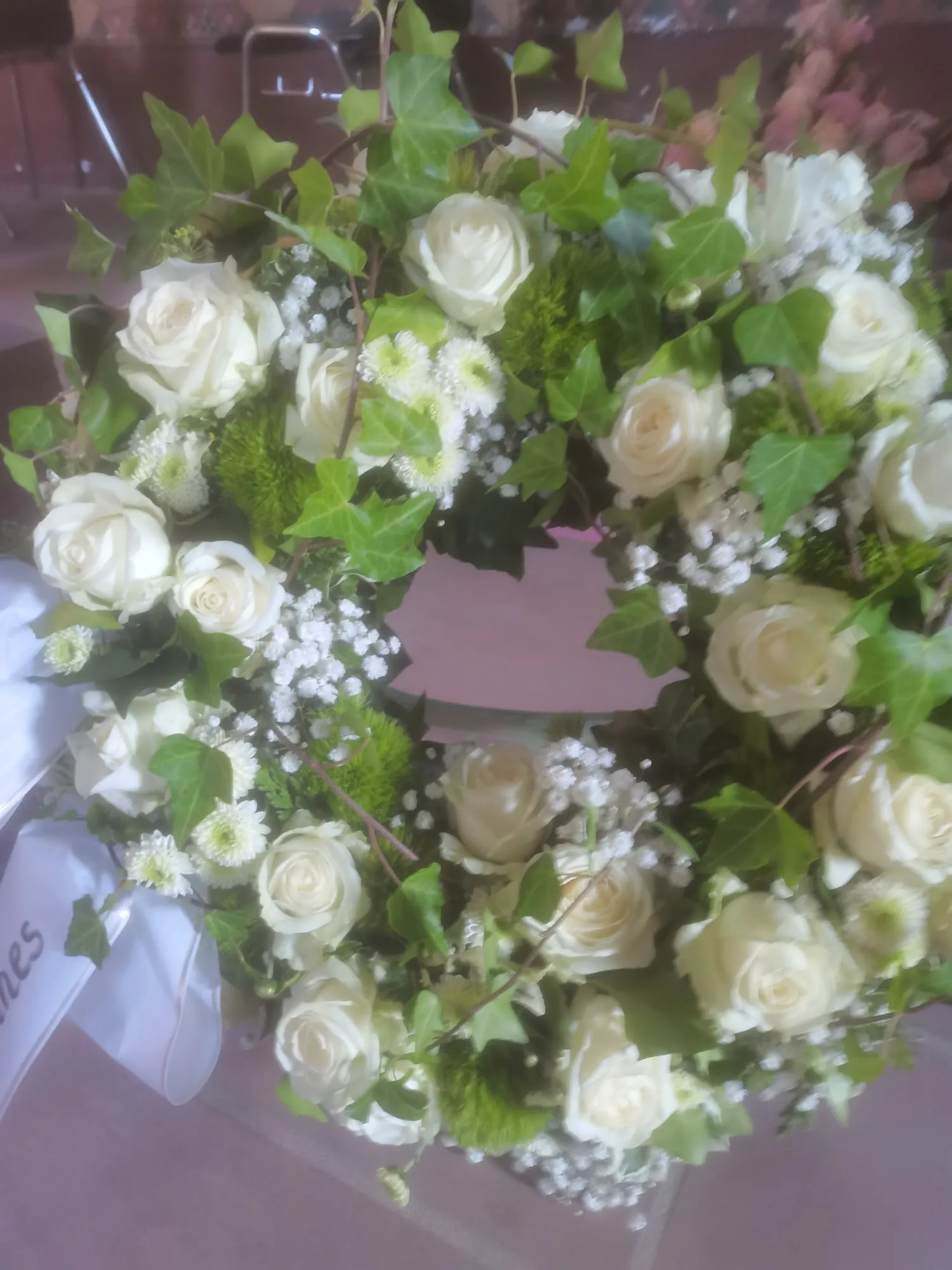 Kranz aus weißen Rosen mit frischem Grün