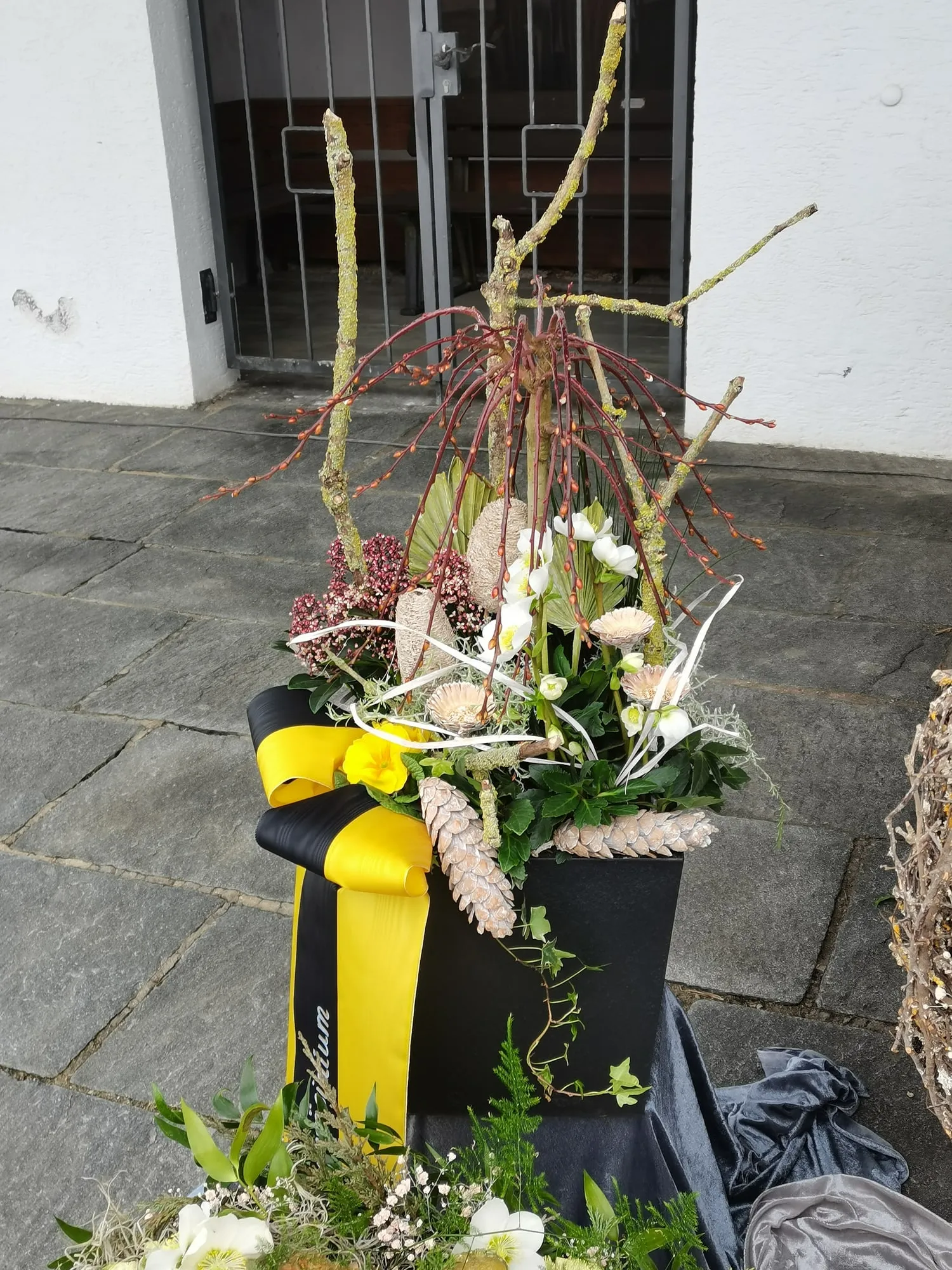 Hohes Gesteck in Gelb mit Zweigen und Gräsern