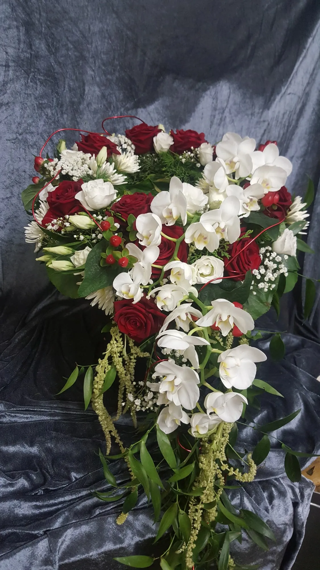 Strauß aus roten Rosen mit weißen Orchideen